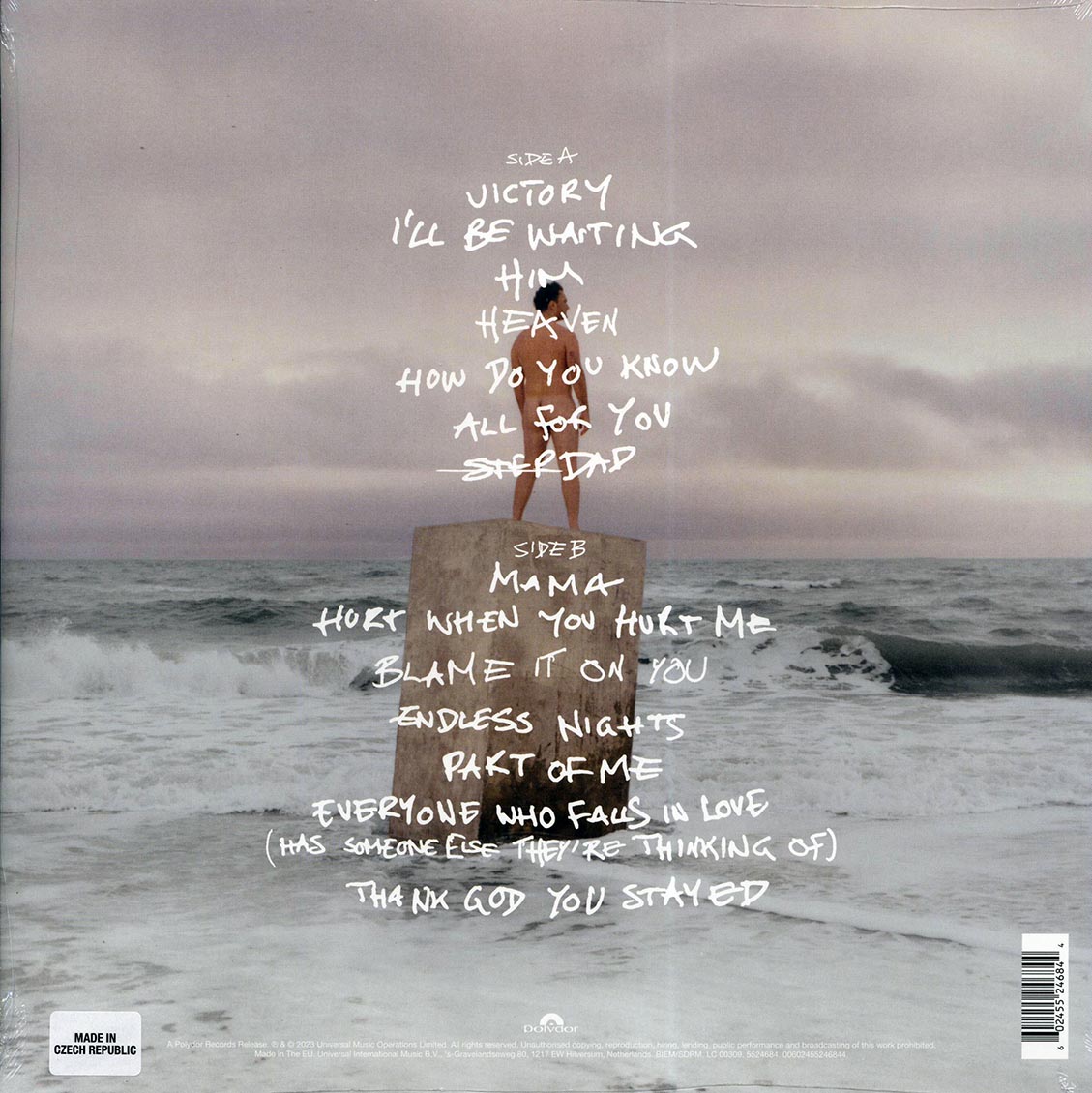 Album cover with text and a person standing on a rock in the ocean